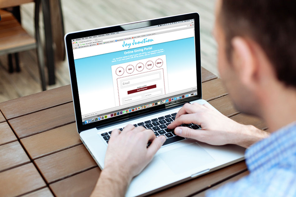 A church member views a church newsletter on his laptop and decides to give through online giving software.