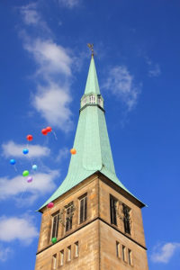 Balloons pass by a church steeple during a church fundraising event.